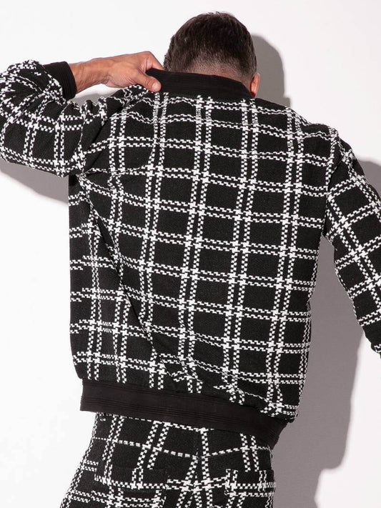 Person wearing a black and white checkered outfit against a white background