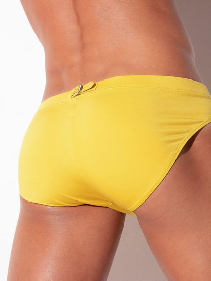 Yellow swim bikini worn by a person on a plain background