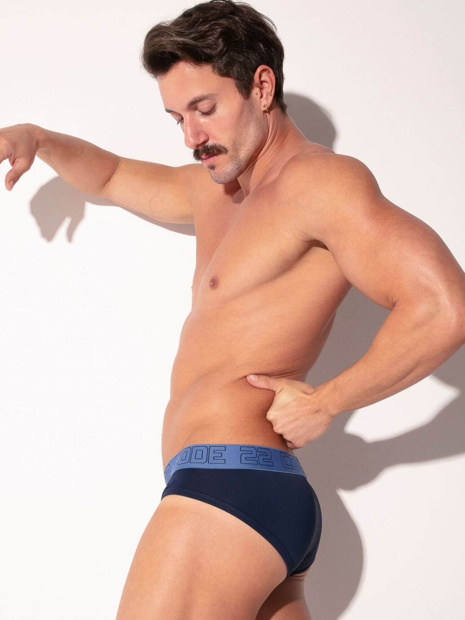 Man wearing blue underwear with a brand logo on a white background