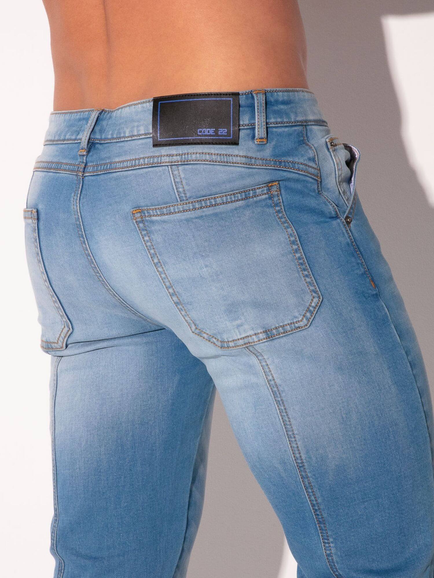 Blue jeans with a visible brand label on a plain background