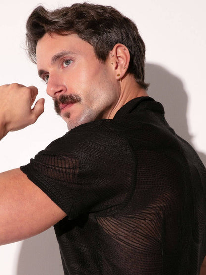 Man wearing a black textured shirt against a white background