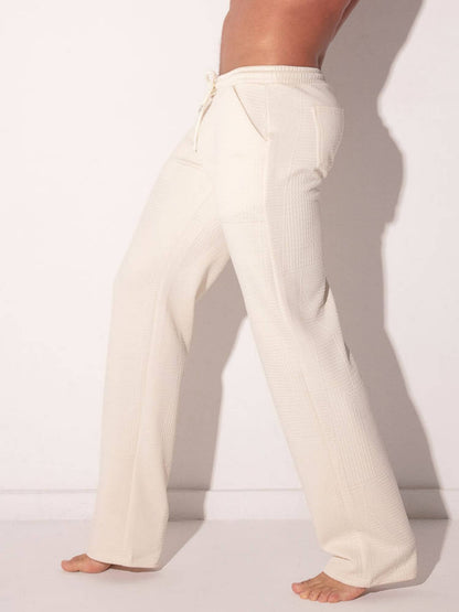 man wearing code22 off-white joggers against a plain background