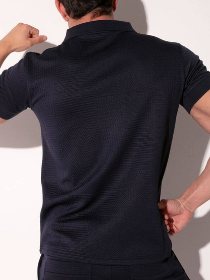 Person wearing a dark blue textured polo shirt against a plain background