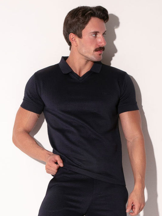 Man wearing a navy polo shirt against a white background