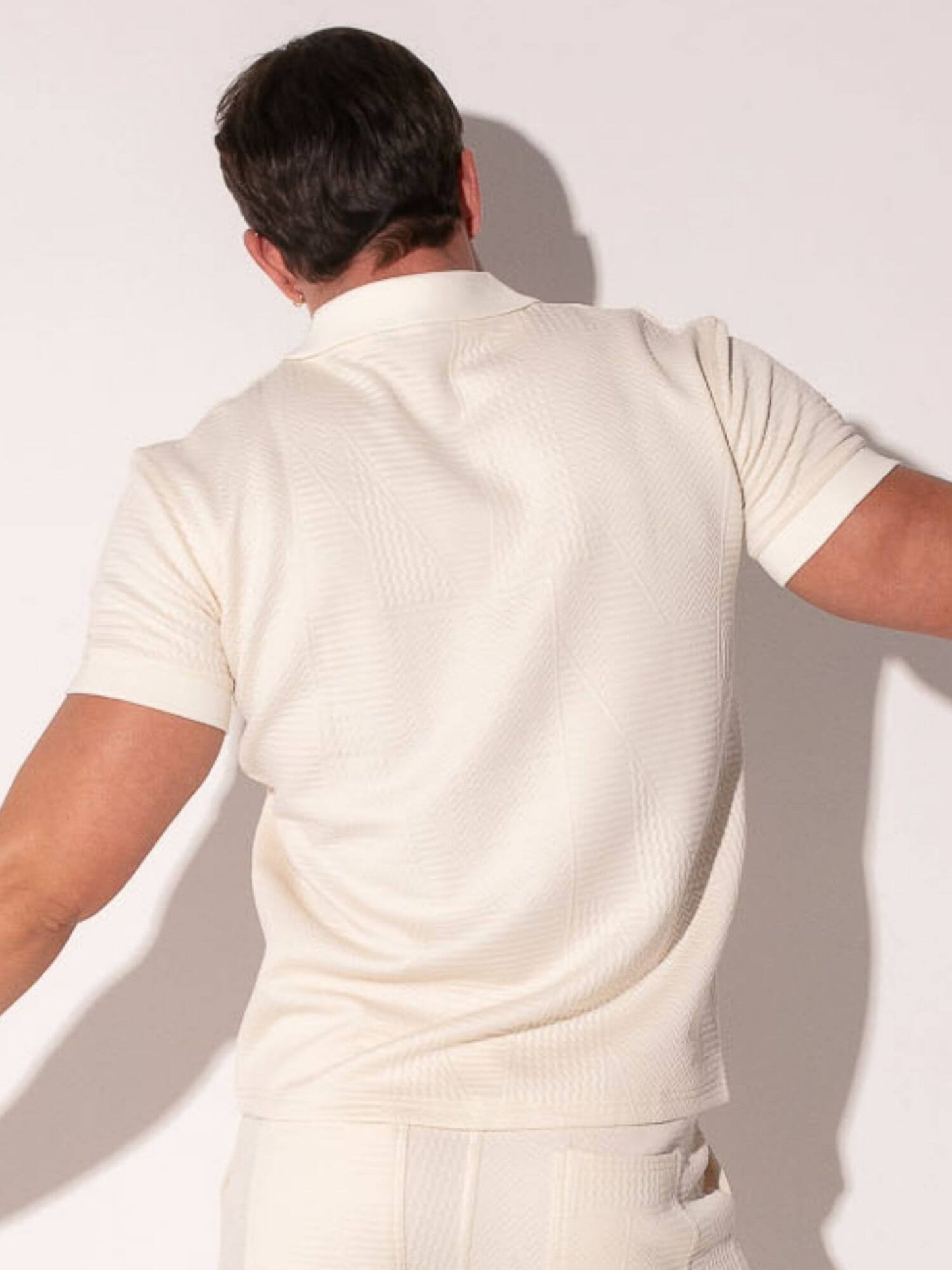Person wearing a off-white outfit against a plain background