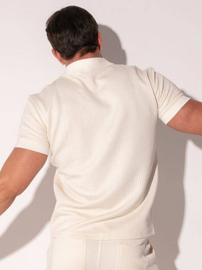 Person wearing a off-white outfit against a plain background