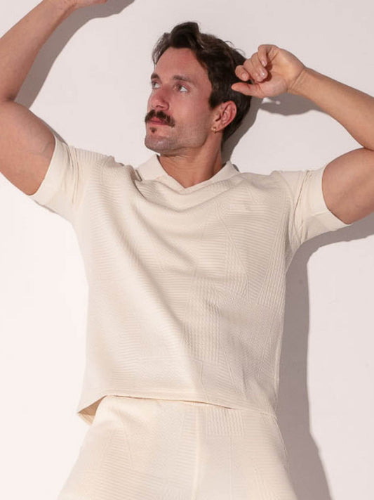 Man wearing a off-white outfit against a light background