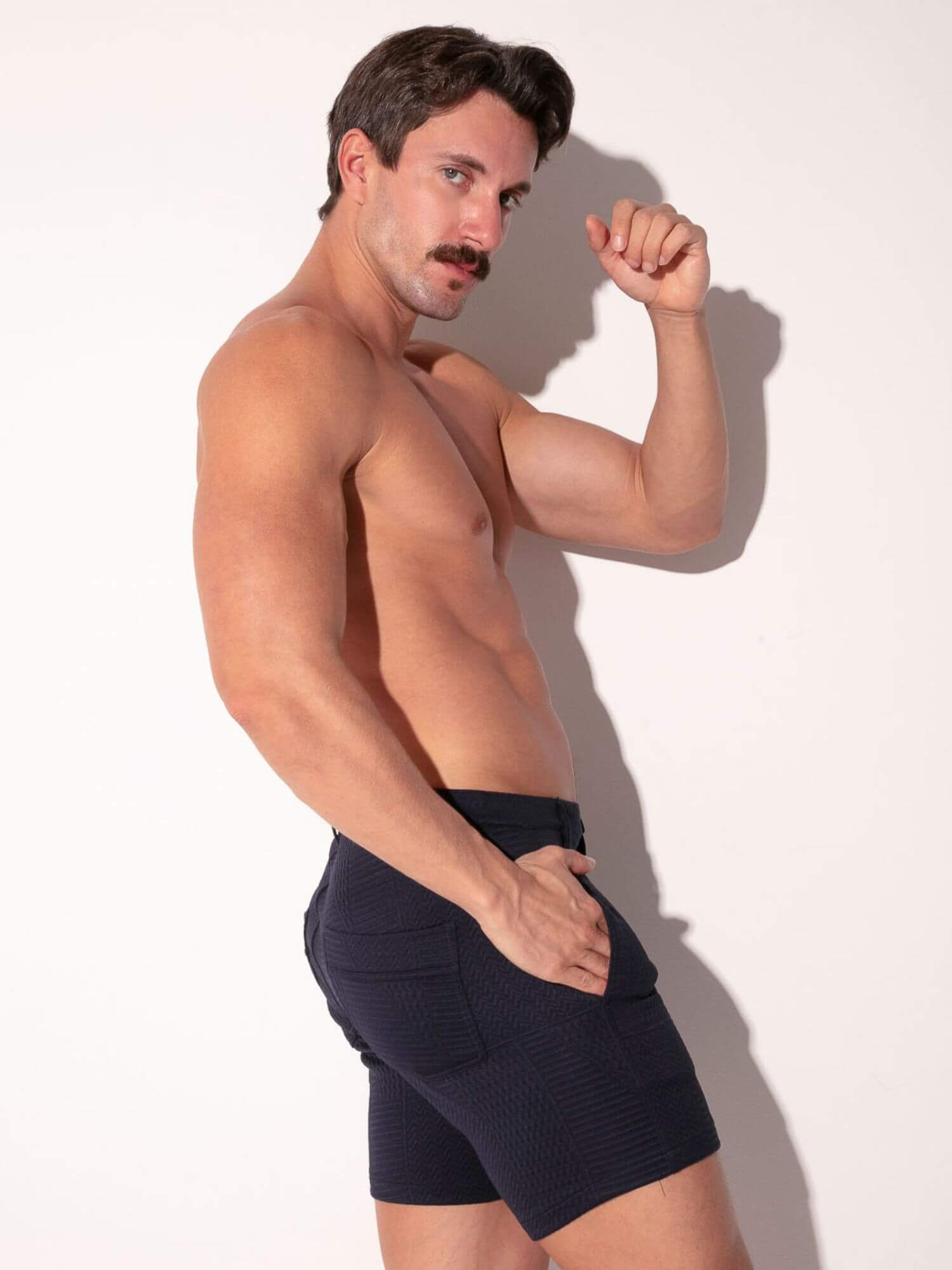 Man wearing navy shorts against a white background