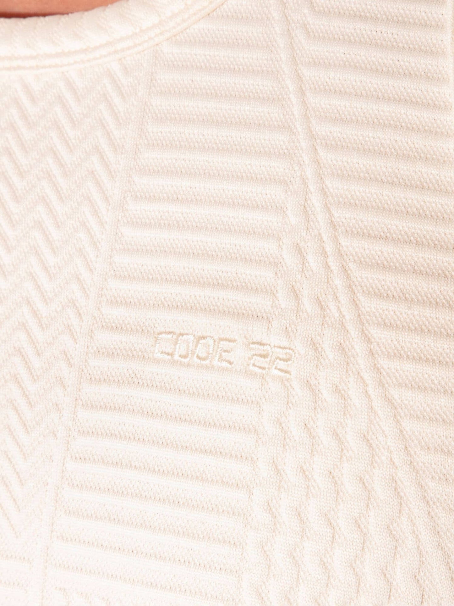 Close-up of a textured beige fabric with a brand logo.