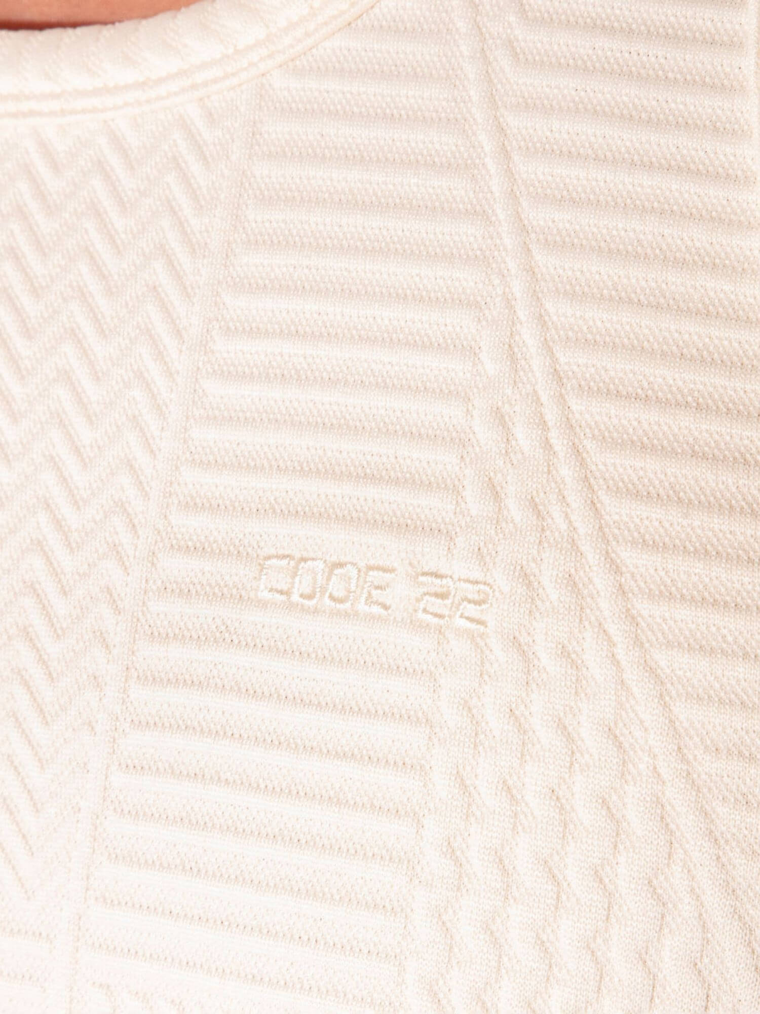 Close-up of a textured beige fabric with a brand logo.