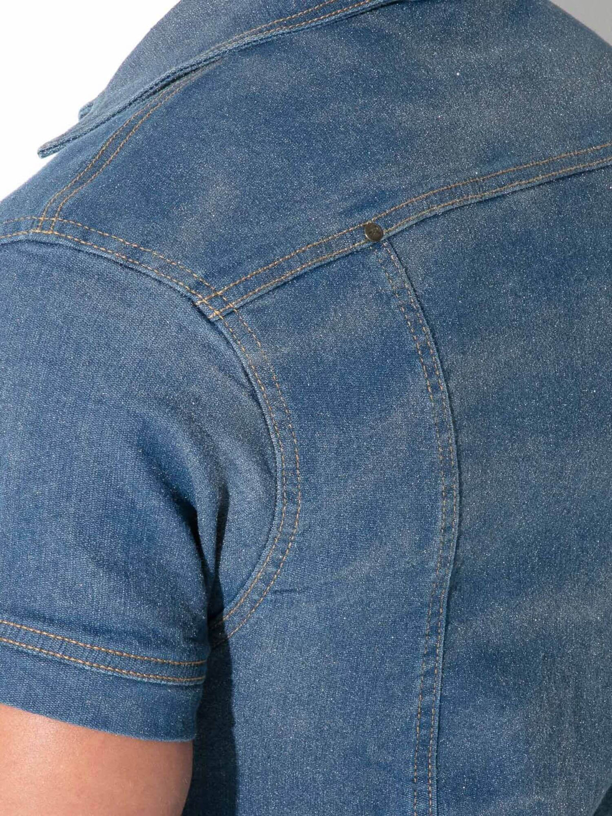Close-up of the back of a blue denim short-sleeve shirt, showing the fabric texture, stitching, and shoulder seam.