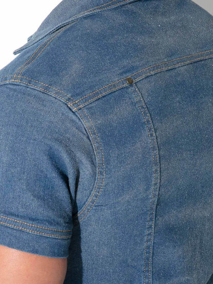 Close-up of the back of a blue denim short-sleeve shirt, showing the fabric texture, stitching, and shoulder seam.