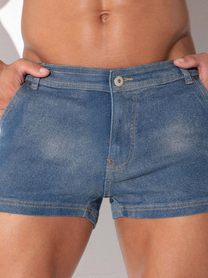 Close-up of a person wearing blue denim shorts, with hands pulling the waistband slightly outward to show the fit.