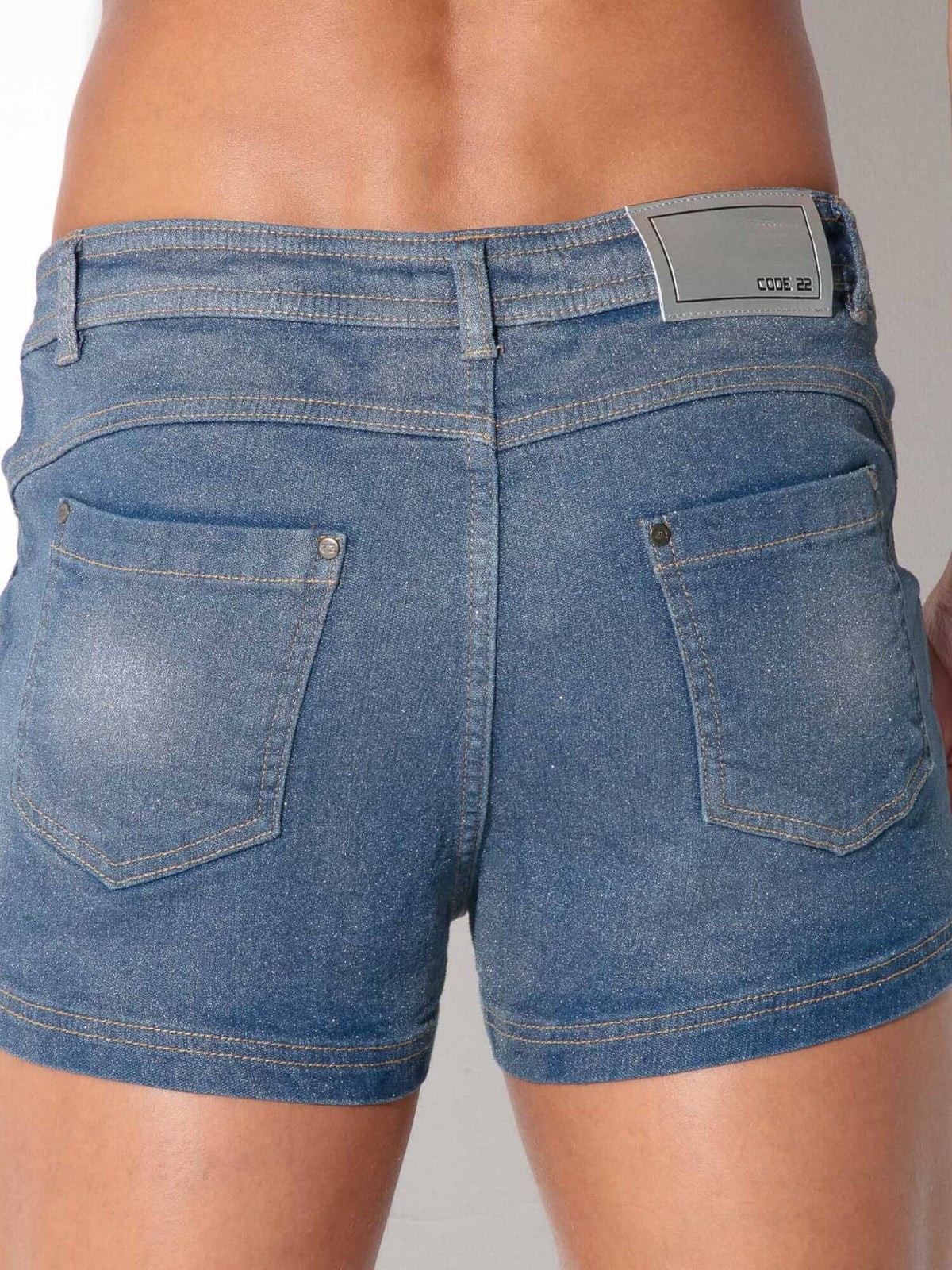 Close-up back view of a person wearing blue denim shorts, showing the waistband, belt loops, back pockets.