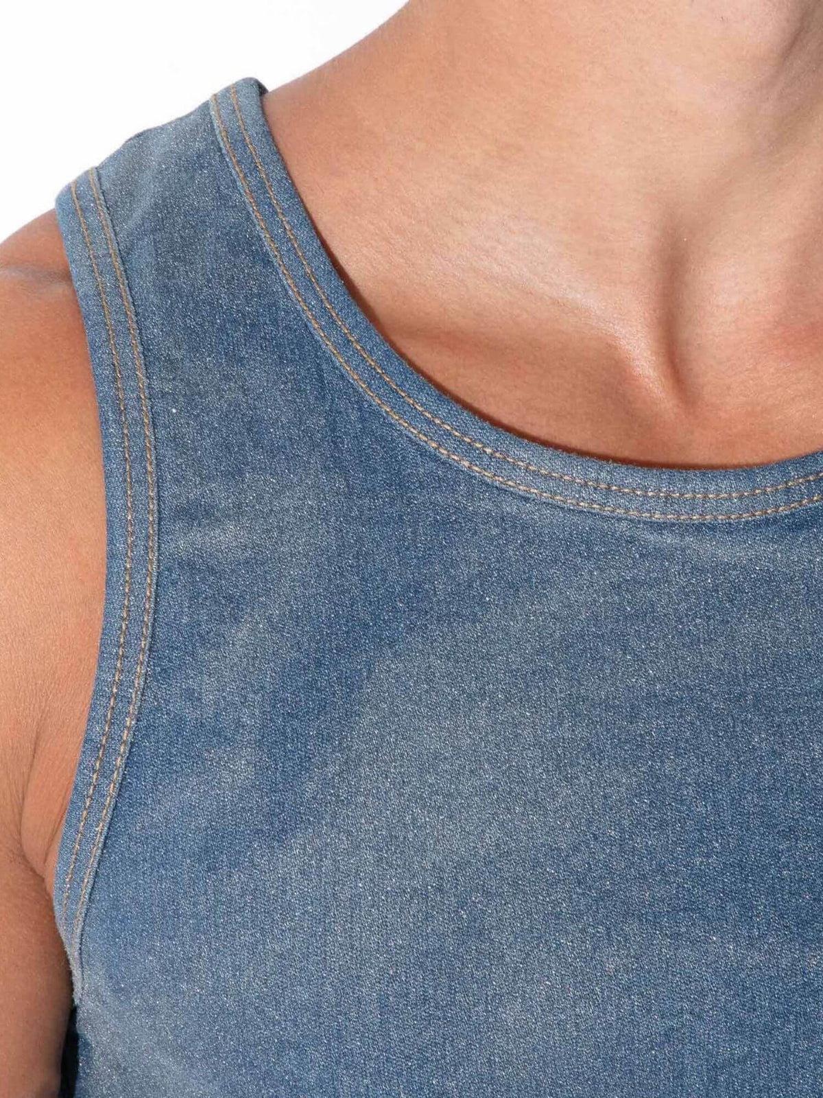 Close-up of a person wearing a blue denim tank top, showing the chest, shoulder, and neck area against a plain white background.