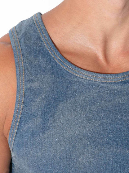 Close-up of a person wearing a blue denim tank top, showing the chest, shoulder, and neck area against a plain white background.