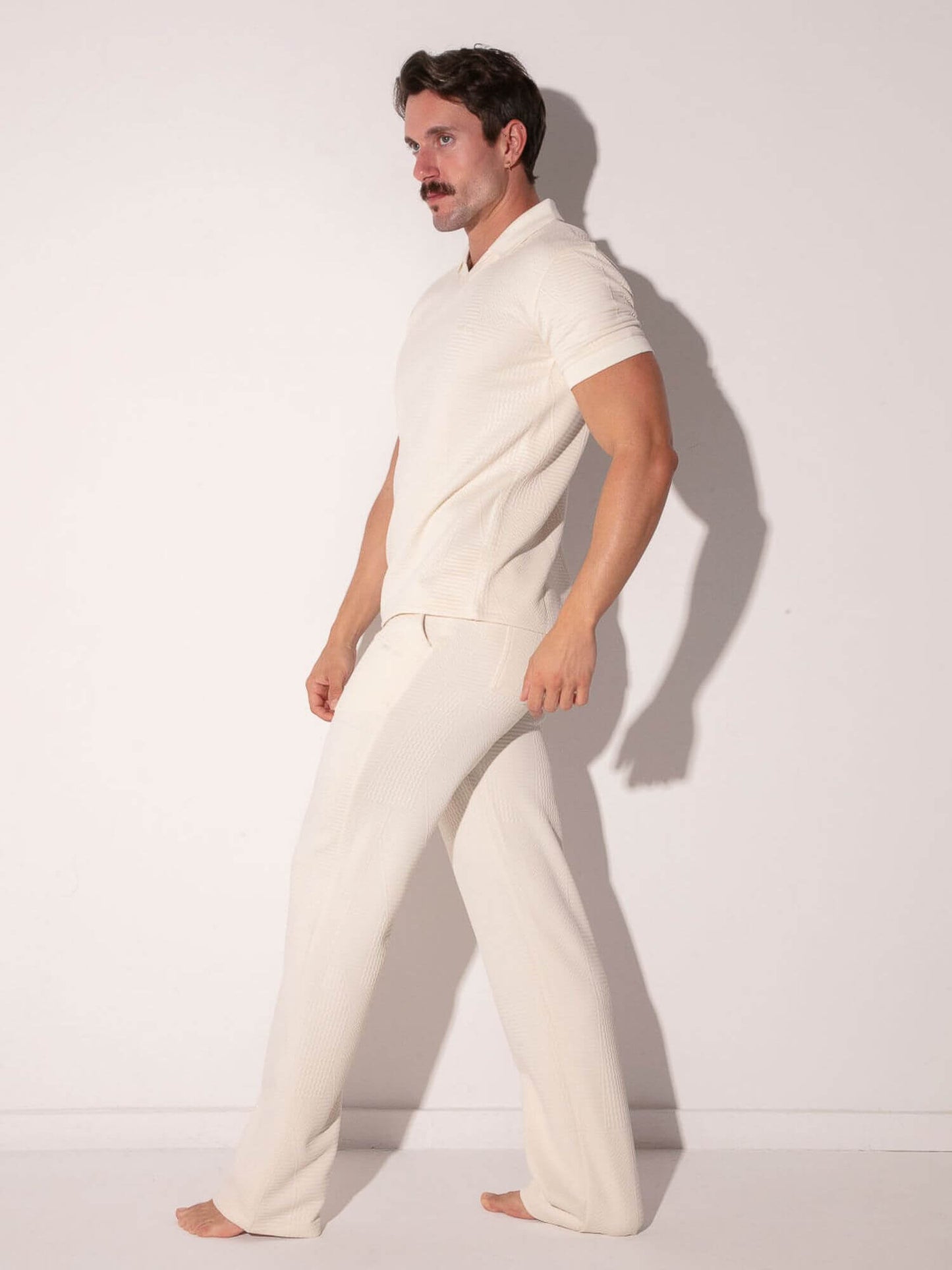 Man wearing a white outfit from the CODE 22 Medley collection against a plain background