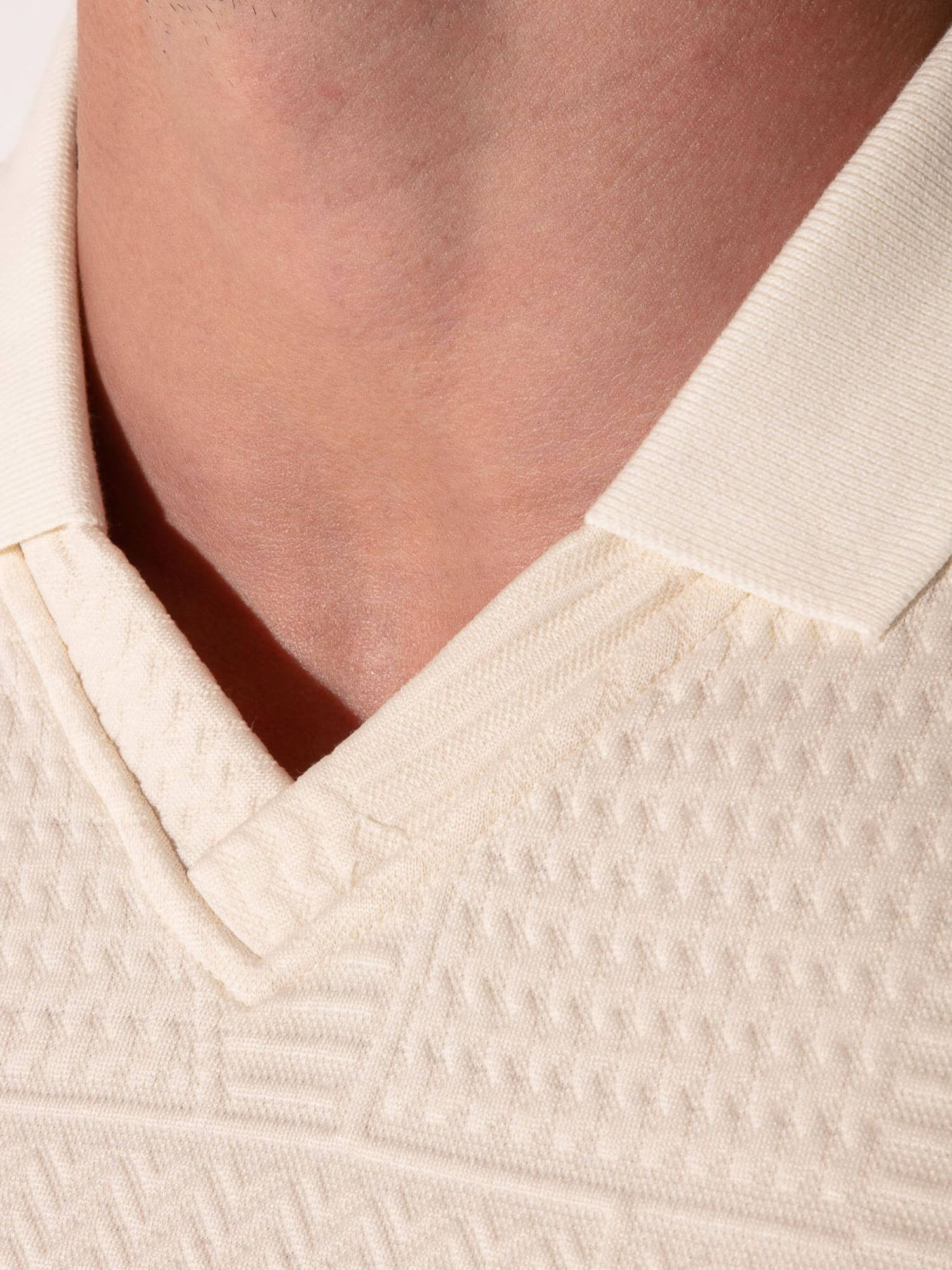 Close-up of a textured beige garment with a collar