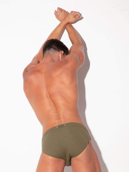 Man wearing olive green underwear against a white background