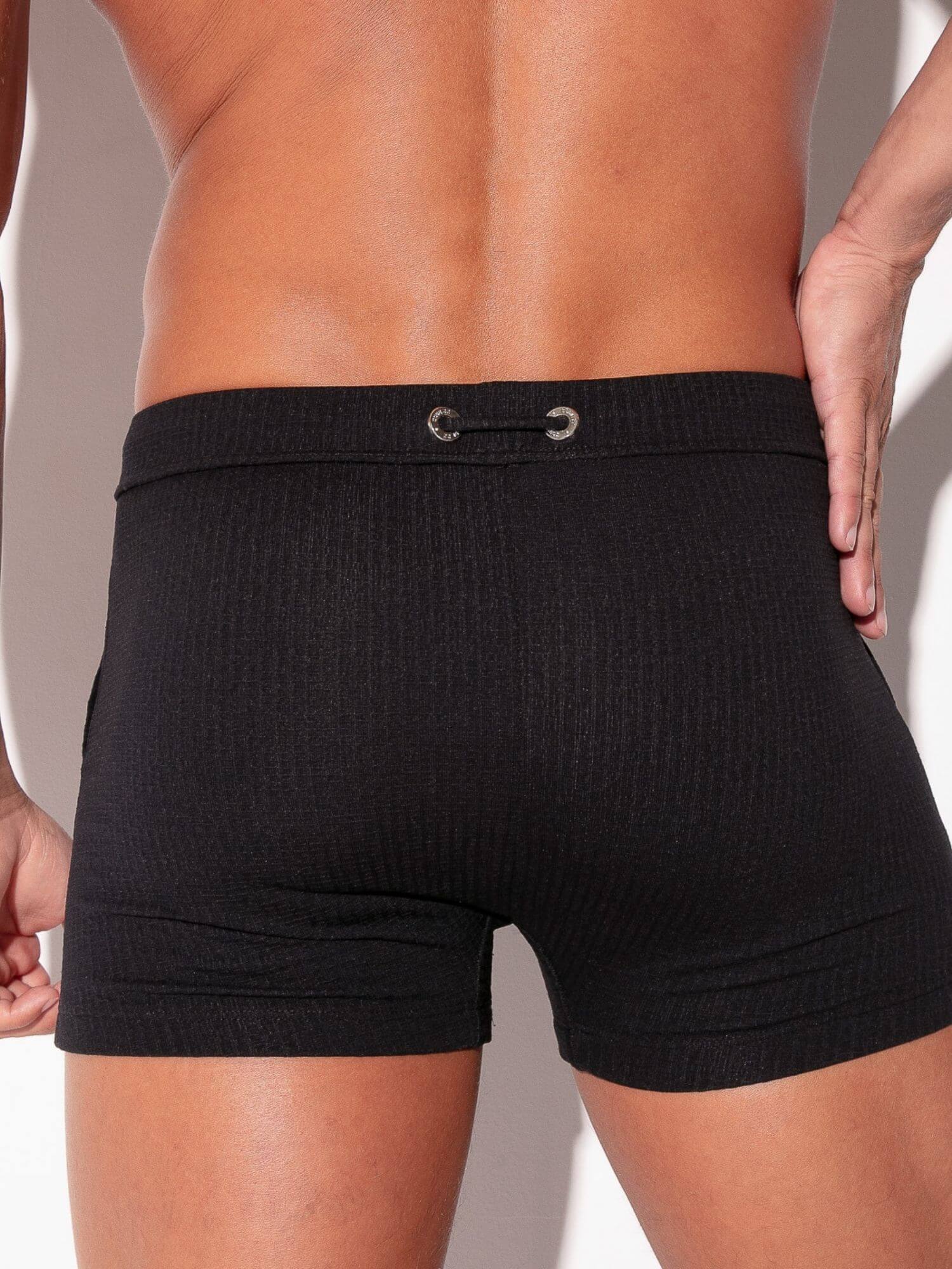 Black swimwear worn by a person on a neutral background