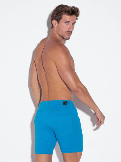 Man wearing bright blue mens cotton shorts on a white background