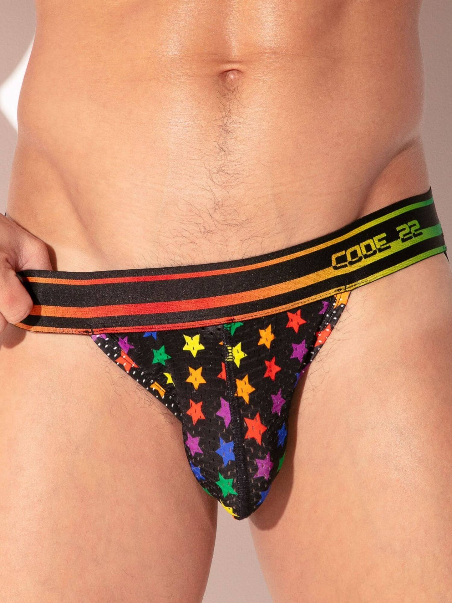 Multicolored star-patterned men's underwear with a colorful waistband on a plain background