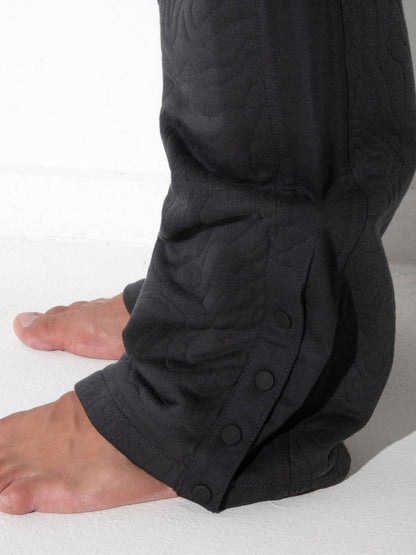 Close-up detail of CODE 22 Quilted Snap-Detail Pants in charcoal