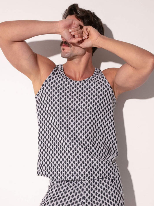 Man wearing a black and white patterned tank top against a light background
