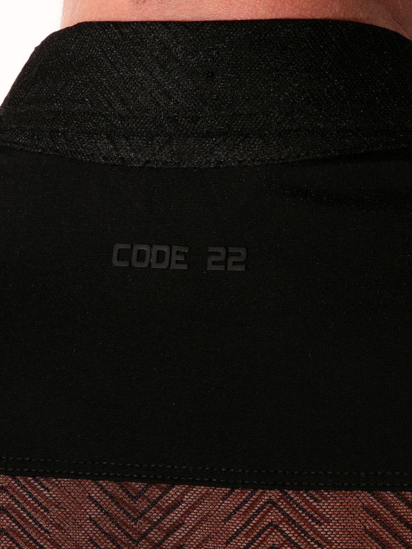 Close-up of a black garment with 'CODE 22' branding.