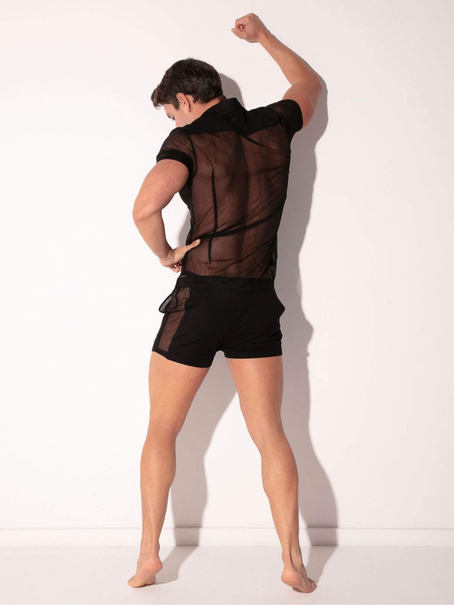 Person wearing a sheer black outfit with a white background