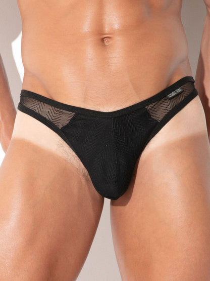 A close-up of a male model wearing black men's underwear with a textured chevron pattern and sheer mesh side panels.