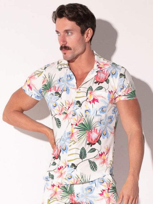 Man wearing a colorful floral shirt against a plain background