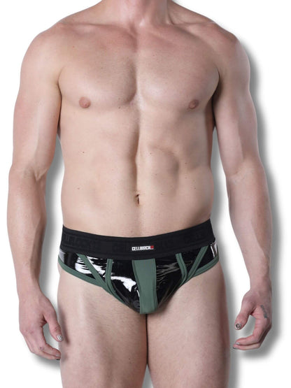 Man wearing a black and green latex thong on a white background