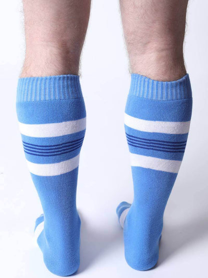 Blue knee-high socks with white stripes worn by a person on a white background