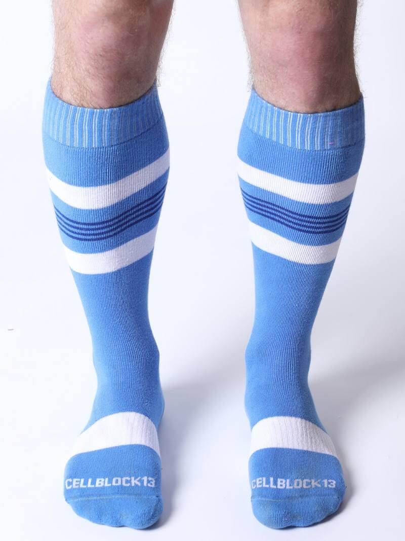 Blue knee-high socks with white stripes worn by a person on a white background
