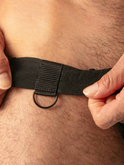 Person wearing a black strap around their waist with hands adjusting it.
