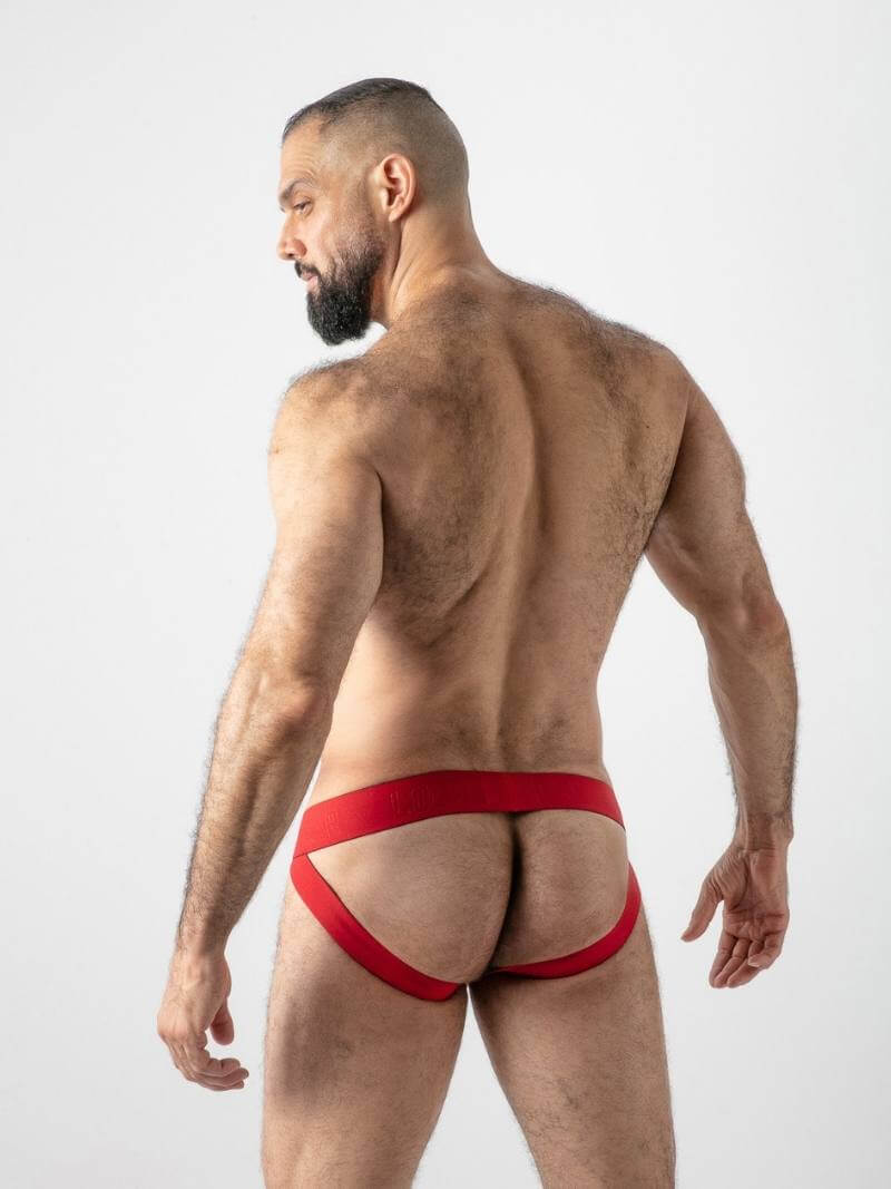 Man wearing red and black athletic underwear against a white background