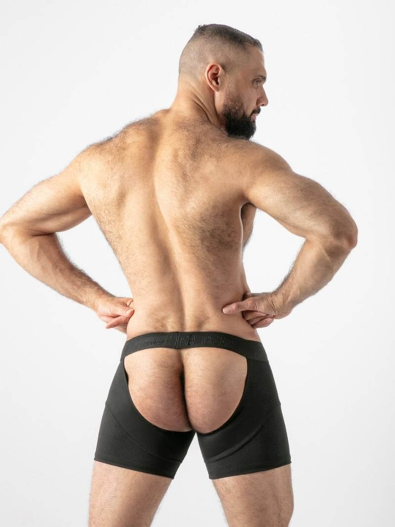 Man wearing black boxer briefs on a plain background