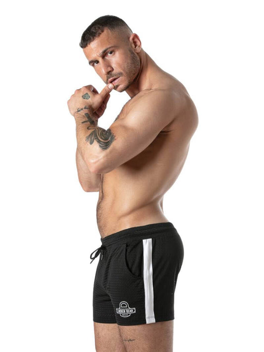 Gay Man wearing black shorts with a white stripe on a white background