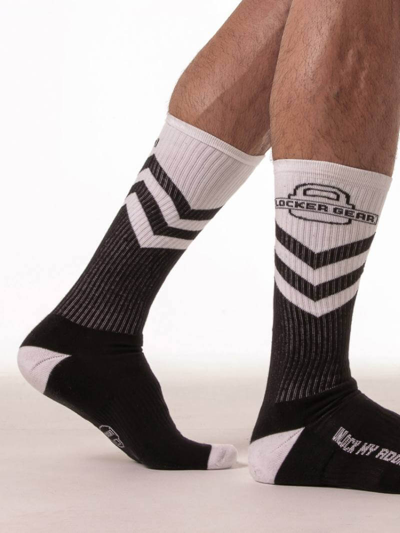 Black and white socks with chevron pattern worn by a person on a white background