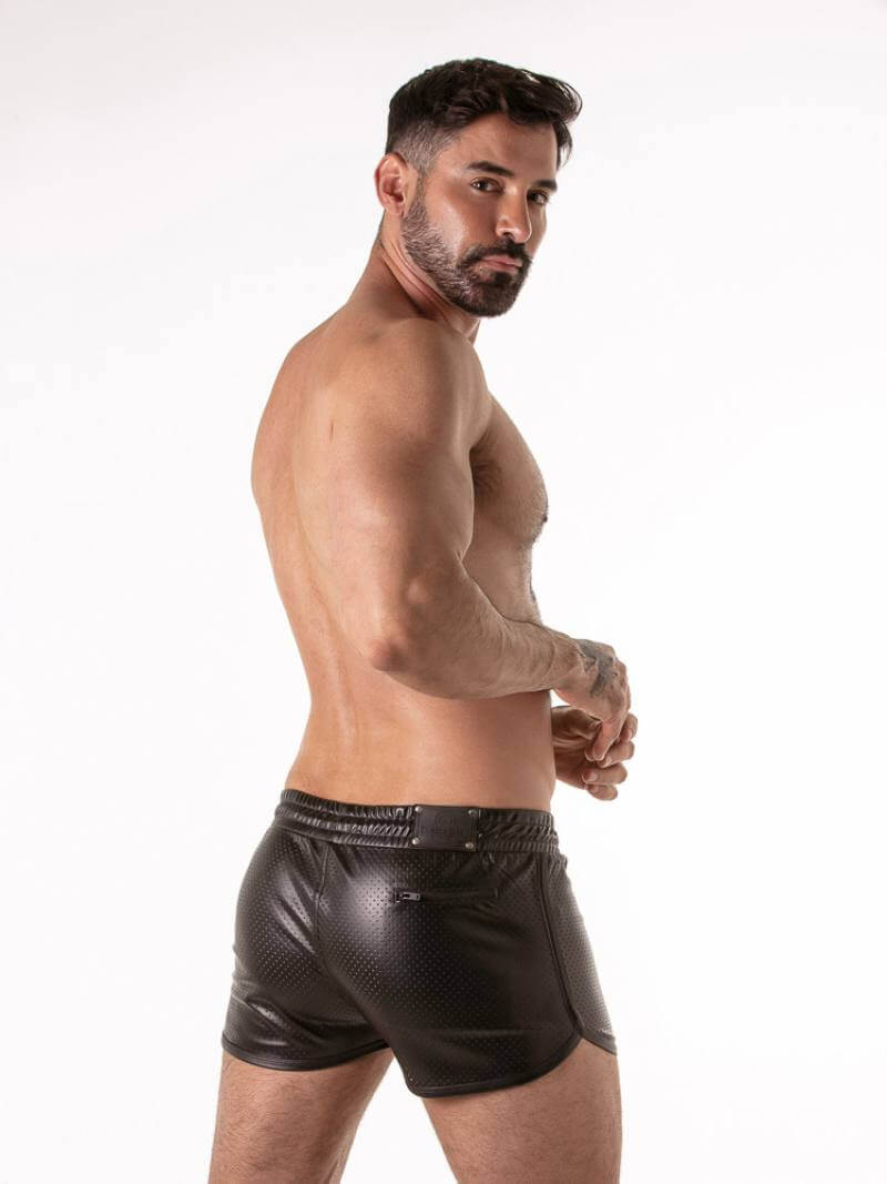 Man wearing black leather shorts on a white background