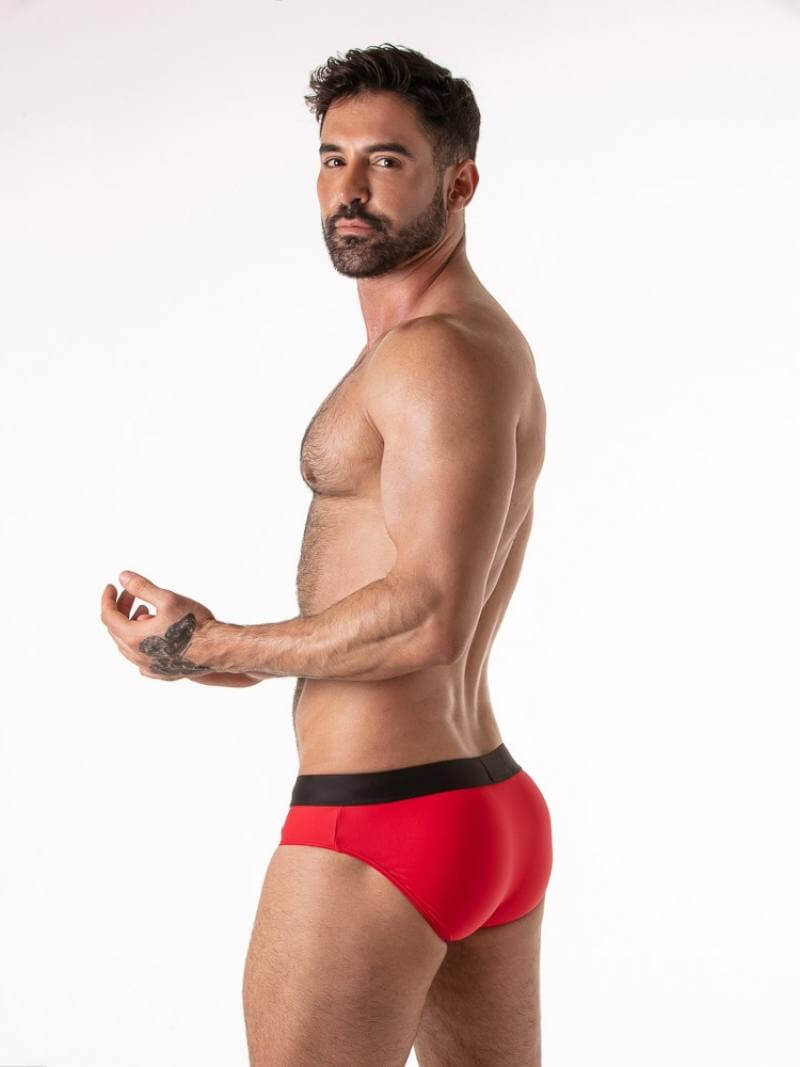 Man wearing red underwear with a black waistband on a white background