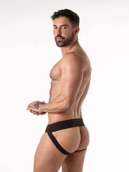 Man wearing a black thong against a white background