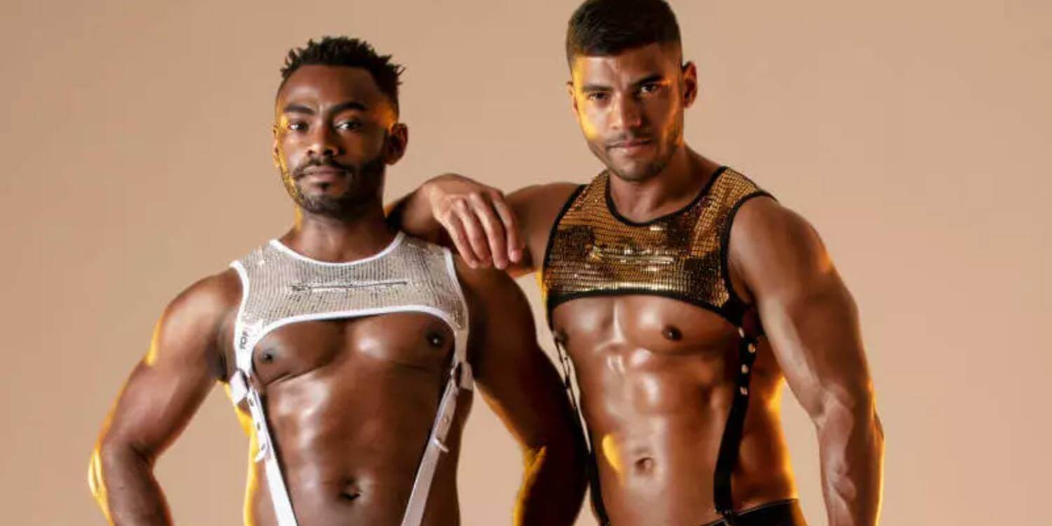 Two men posing in revealing outfits against a beige background