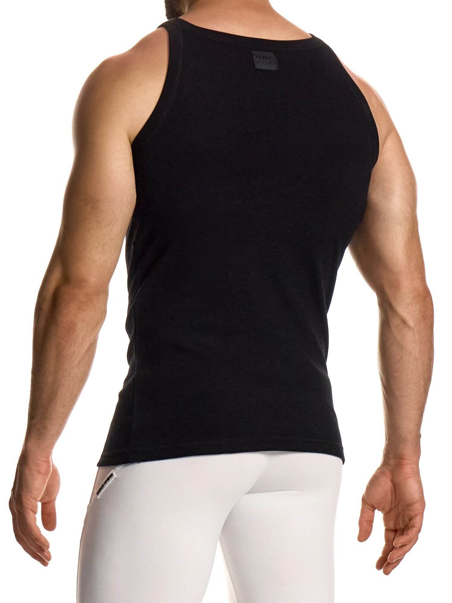 Person wearing a black tank top and white pants on a white background