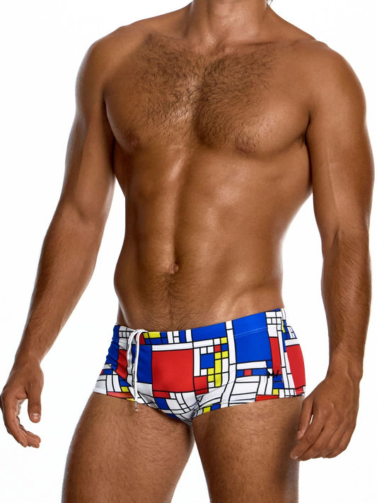 Man wearing colorful swim trunks with a geometric pattern on a white background