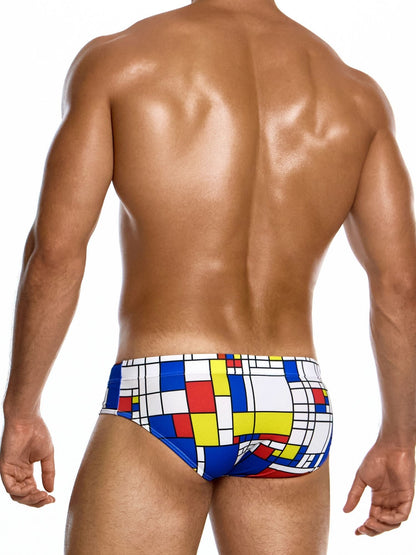 Colorful swim briefs with a geometric pattern worn by a person on a white background
