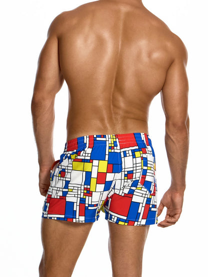 Man wearing colorful geometric patterned swim shorts on a white background