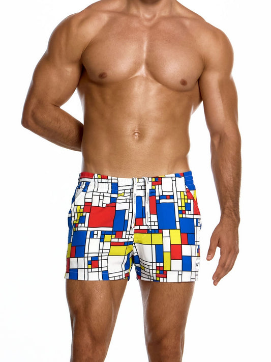 Man wearing colorful geometric patterned swim shorts on a white background