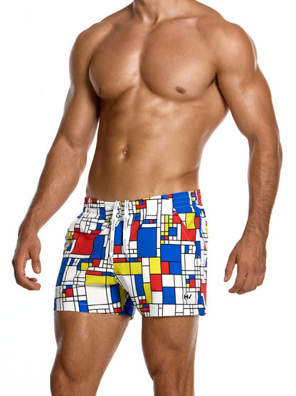 Man wearing colorful geometric patterned swim shorts on a white background